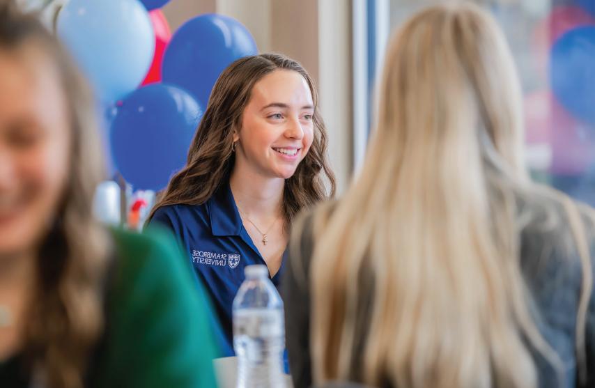 A student smiling while talking to someone